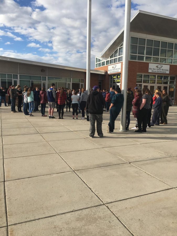 Big Sky students who walked out of class stand, holding signs, and some even comforting each other quietly for 17 minutes.