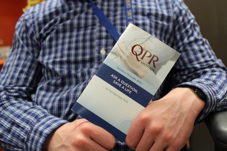teacher holding QPR handbook