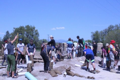 Group of students putting sand into bags.