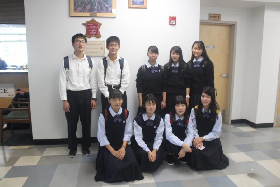 Students in uniforms smile in the hallway