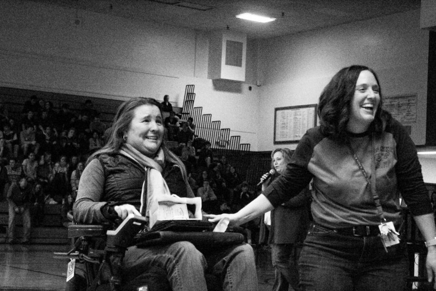 Two woman smiling in an auditorium