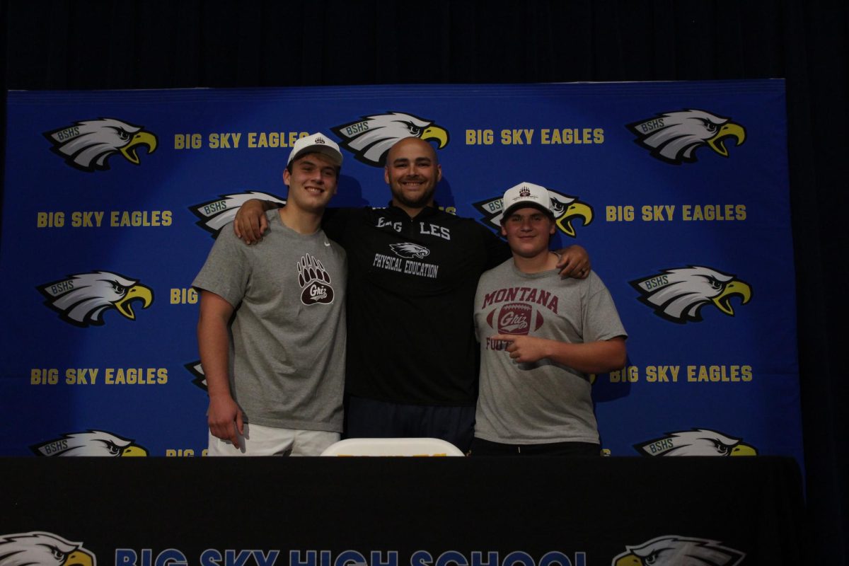 Spencer Tripp (right) and Ezra Meyer (left) posing with Coach Payton Stoner (middle) after signing to play football with the University of Montana.